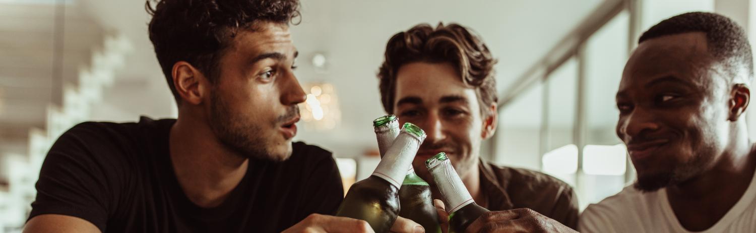 Photo of three male students drinking together.