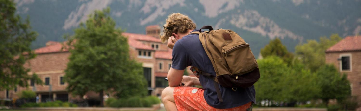 Photo of a student looking sullen on a bench at Farrand Field.