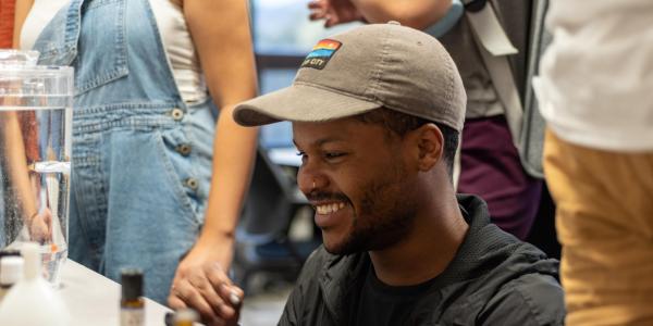 student in a hat smiling