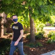 Two students in masks walking on campus.