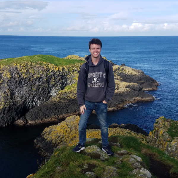 Patrick Heffernan stands on a rock overlooking a body of water.