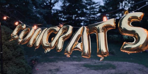 Gold metallic ballons spell out CONGRATS