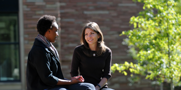 2 people talking outside on CU Boulder campus