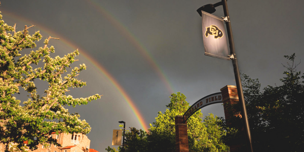 double rainbow in the background of campus near the stadium
