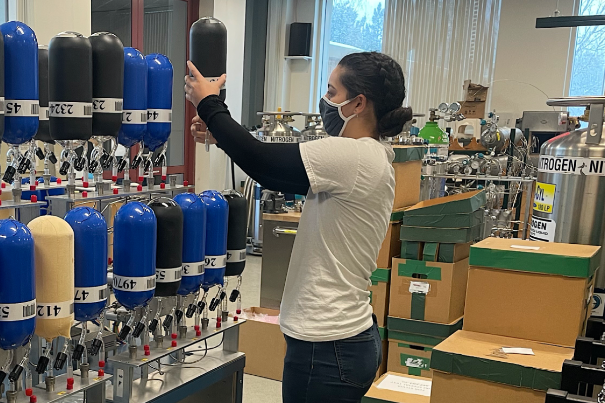 Lab technician works with a wall of air sampling flasks