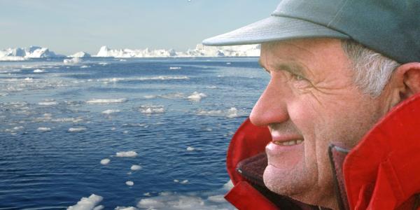 Profile view of John Andrews' head looking out over a sea-ice covered arctic sea 