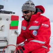 Scientist works on equipment while on sea ice