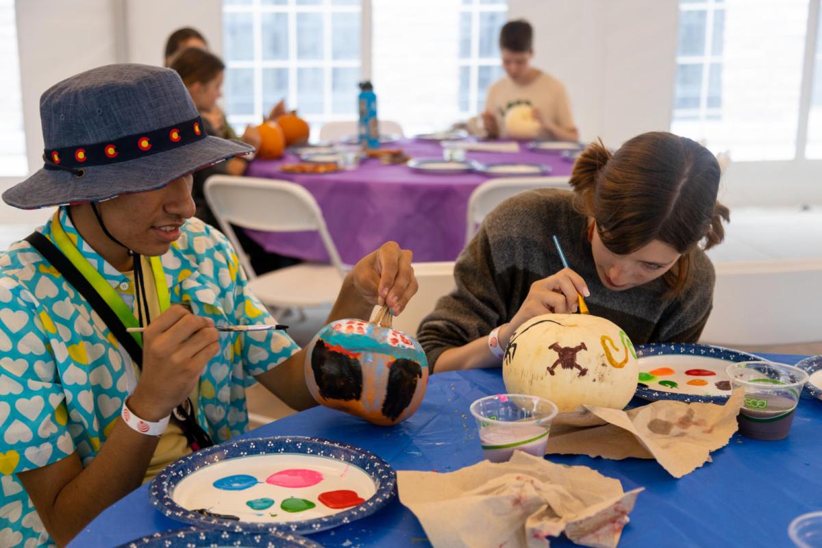 students painting pumpkins