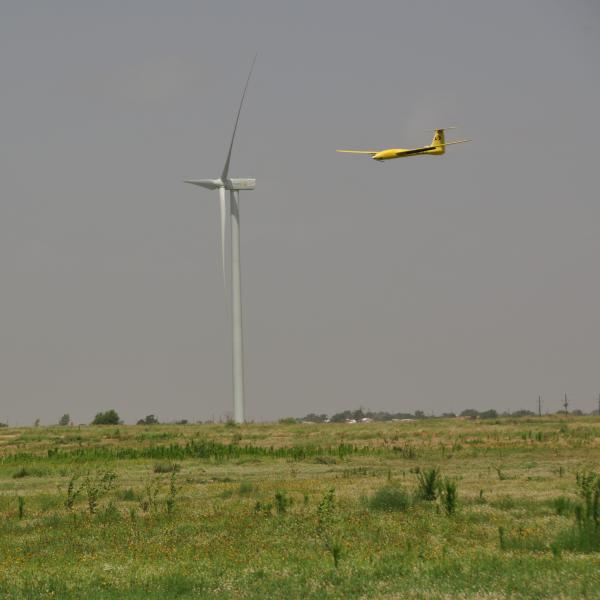 Tempest UAS flying in front of a wind turbine on approach for landing