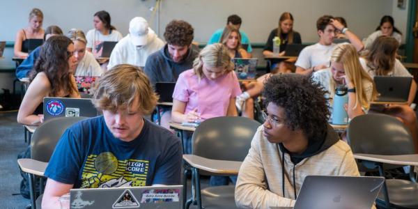 Students sitting at their desks in a Jewish Studies classroom discussing work