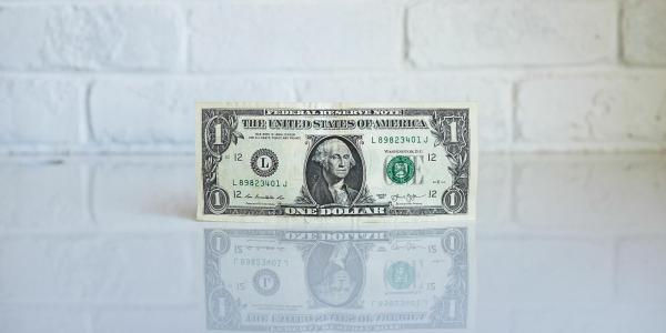 Dollar bill balancing on its edge. 