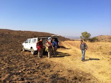 Team near truck in burned grassland