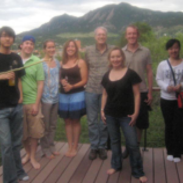 Group members posing together on a deck outside