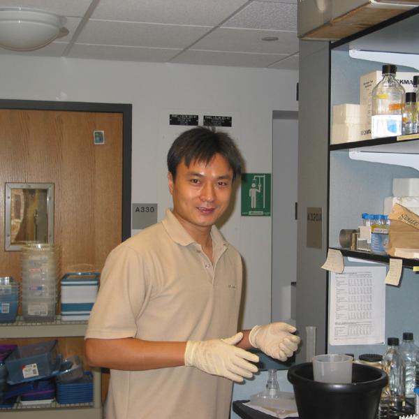 Yong Shi Posing Next to a Lab Bench
