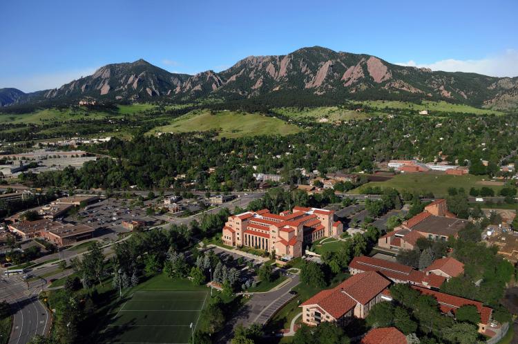 Aerial shot of the law school building with the Flatirons in the background