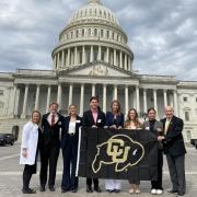 CFL students and staff posing with a CU Boulder flag in front of the US Capitol