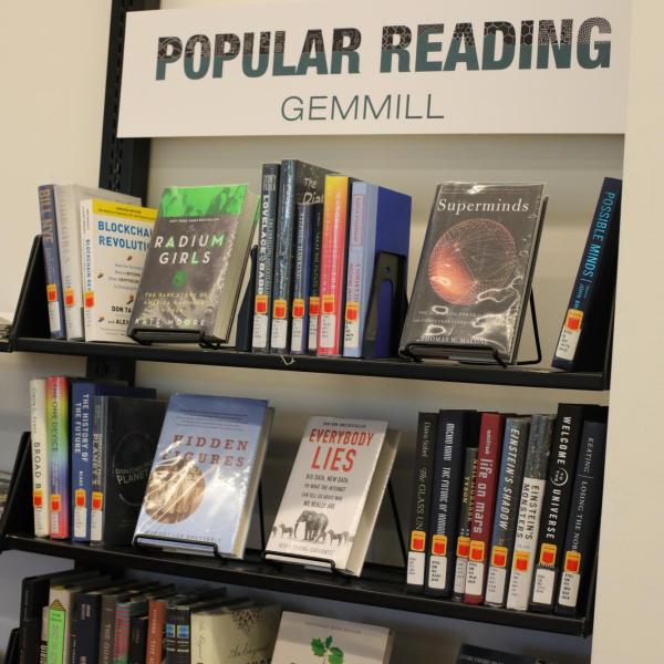 bookshelf with sign Popular Reading Gemmill at the top, holding four shelves of books with colorful colors