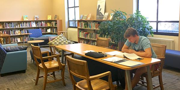 A student works at a table near the C&YA Collection