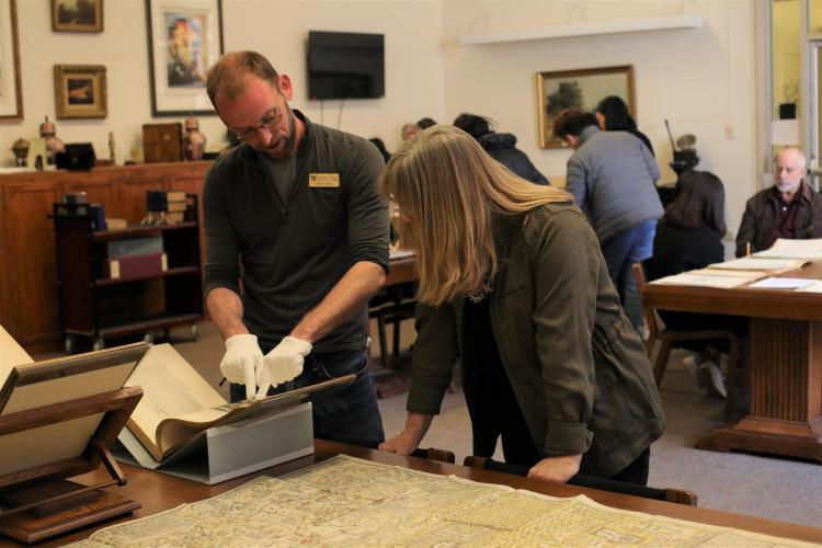 University Libraries' Adam Lisbon and Susan Leigh Guinn-Chipmann look at rare items from the Asian Studies collection. 