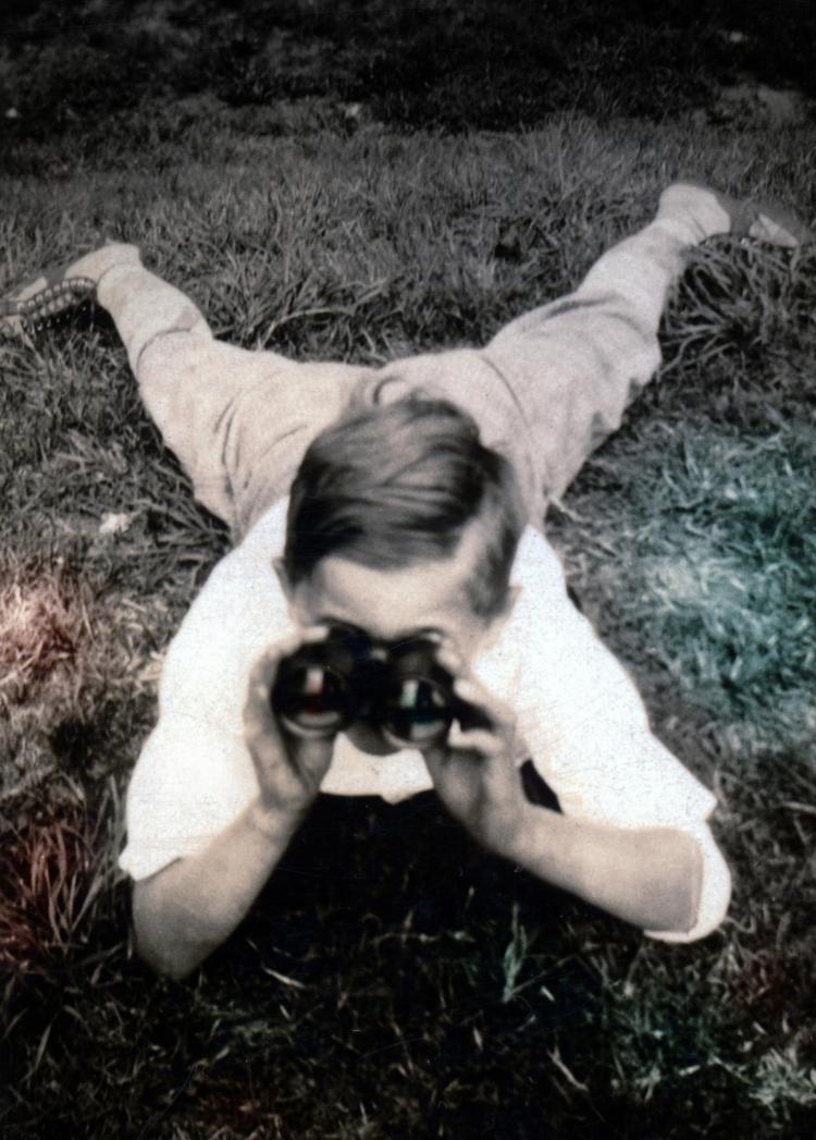Young William Weber holding binoculars