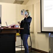Fellow Julia demonstrates how to use VR goggles during her presentation.