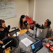 Three students in discussion for podcast.