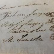 Closeup on Abraham Lincoln and Mary Todd Lincoln's signatures on a land dead from Special Collections