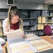 A student working in the Libraries' Archives, sorting papers.