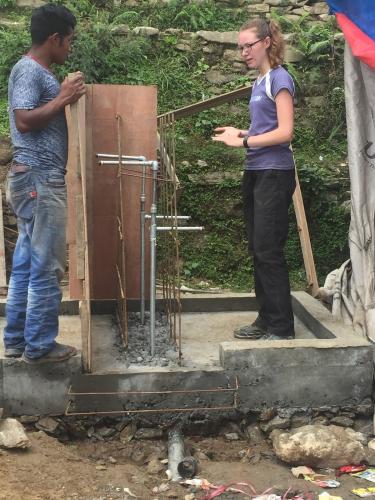 Emily (right) discusses concrete forming for tapstand construction.