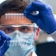Man examines a vial in a lab