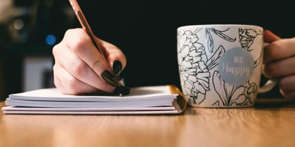 Woman writing with cup