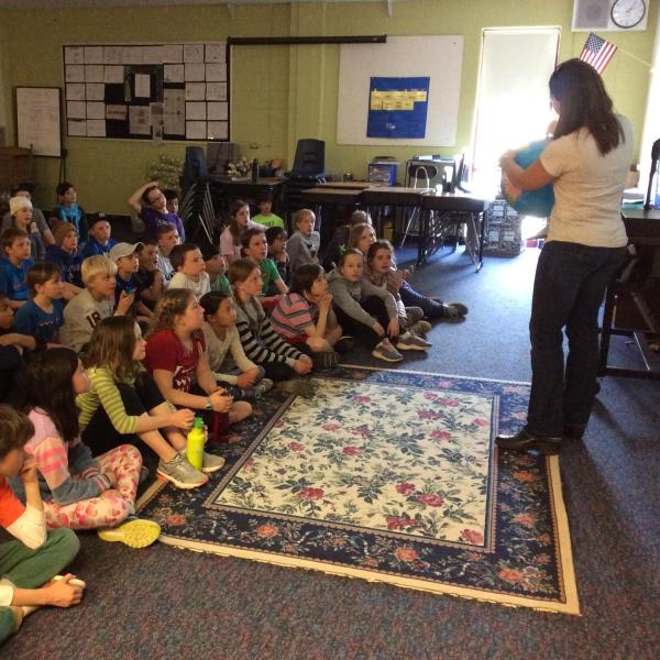 Photo of scientist in front of a classroom of fourth graders