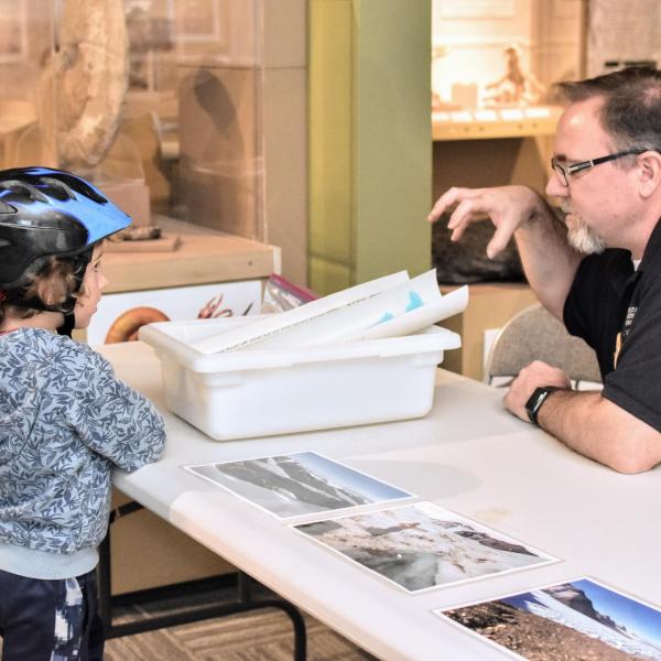 Dr. Mike Gooseff demonstrates glaciers using slime to a small child.