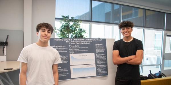 Two students pose with their research poster during the SCENIC symposium