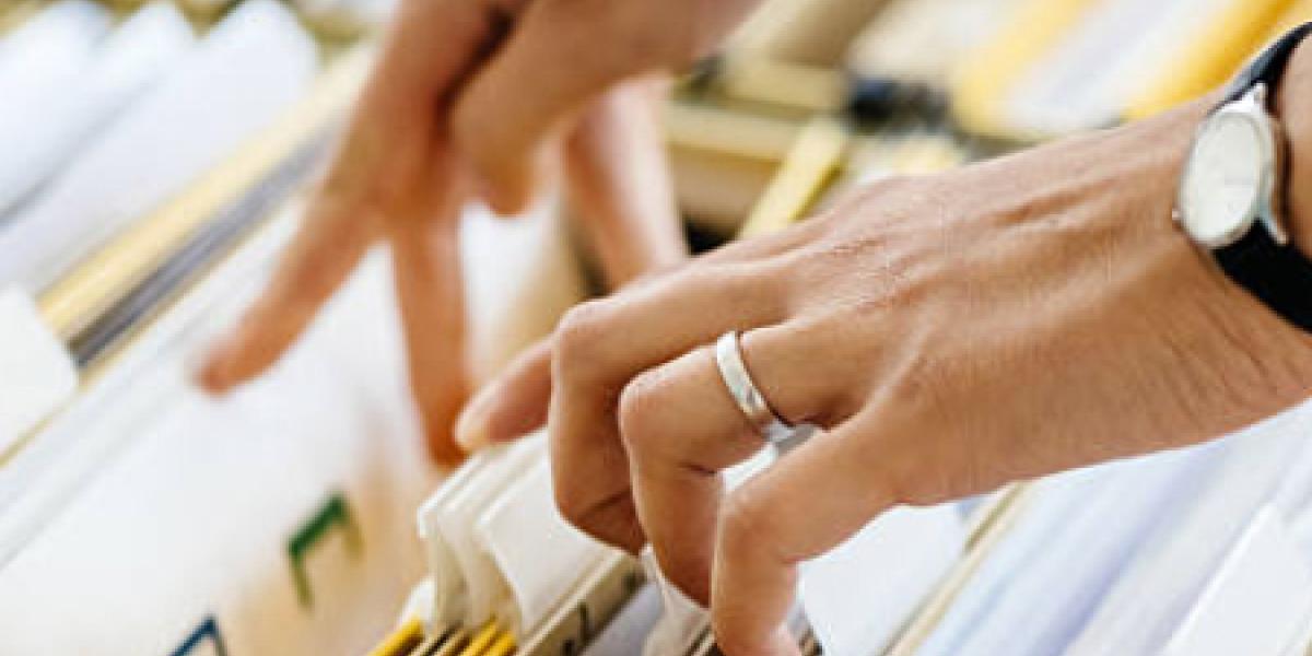 A person pulling a file out of a filing cabinet