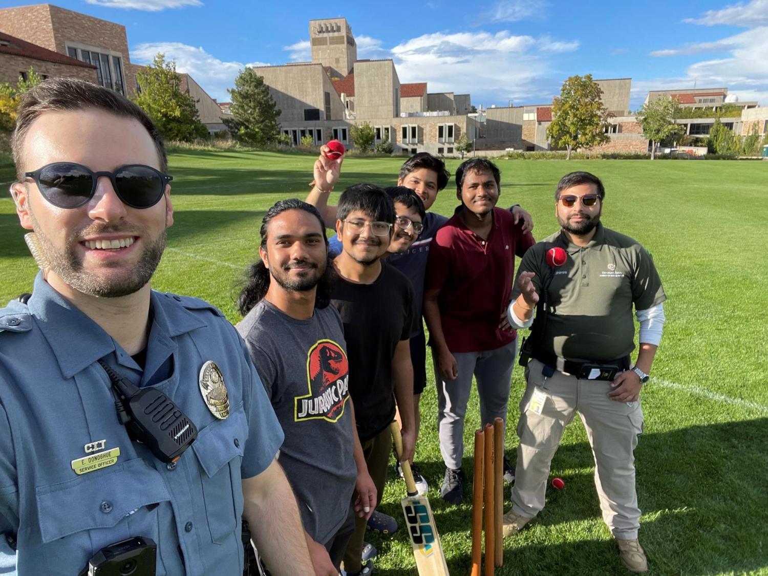 Officer poses with students after playing game