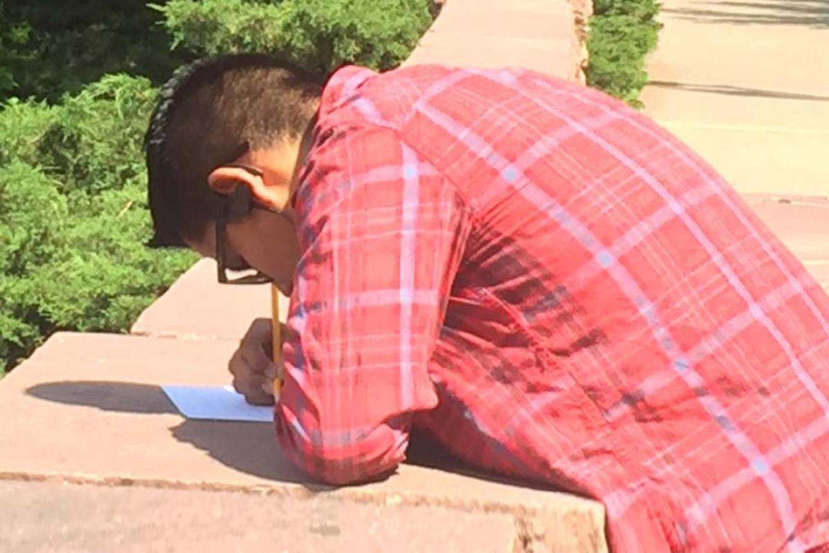 a CUUB student writing on a piece of paper