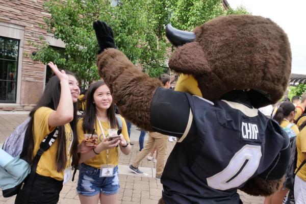 two students giving high fives to Chip the Buffalo, CU's costumed mascot
