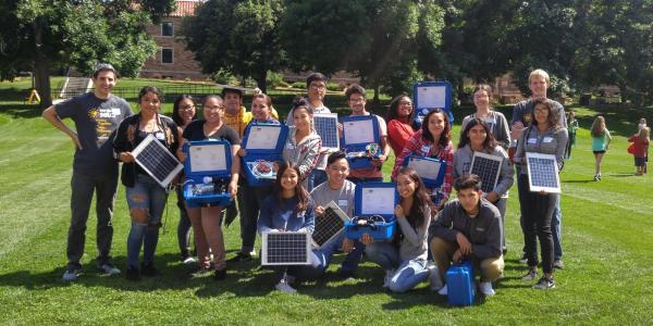 a group of STEM program participants holding the solar panel cases they built