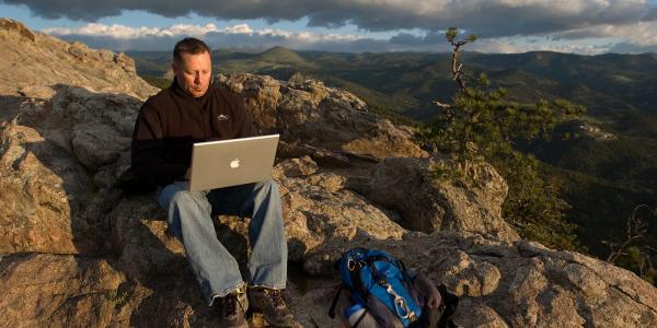 Man on mountain with laptop