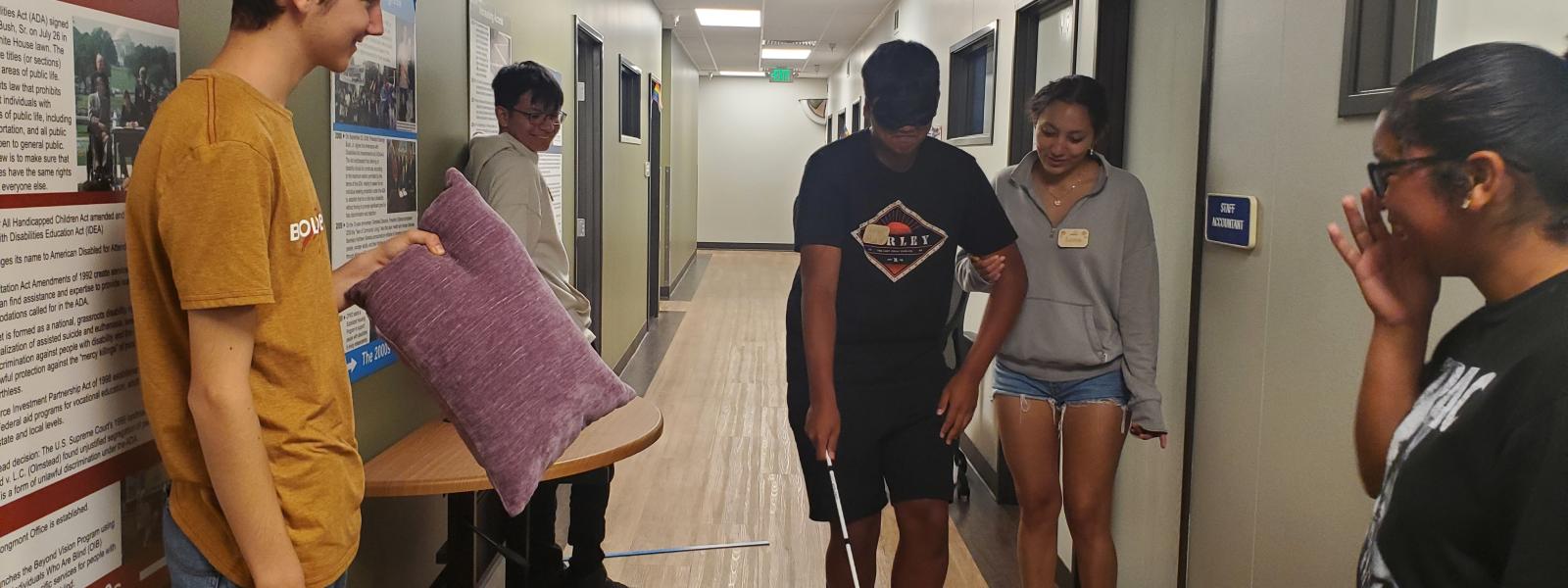 a blindfolded teen navigating obstacles