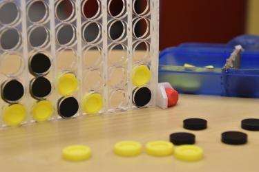 Closeup of Connect 4 stand and playing pieces.