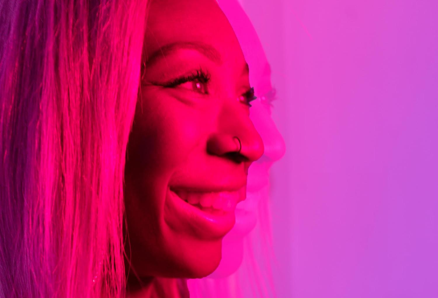 Woman smiling in a pink lit room