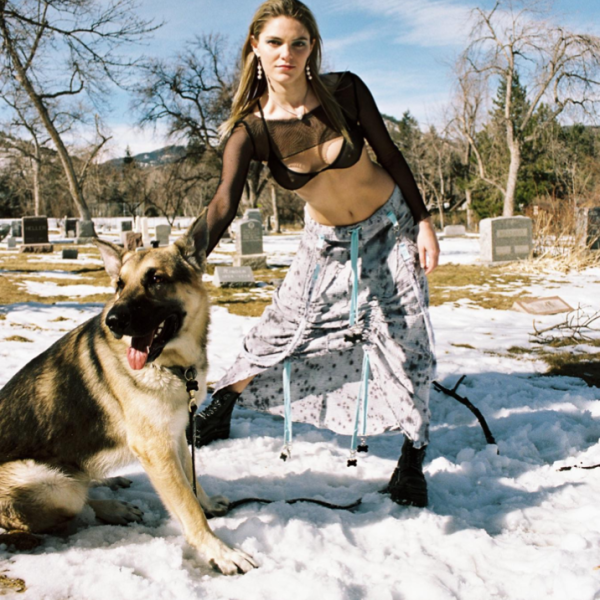 Woman in fashion outdoors with a german Shepard dog by her side