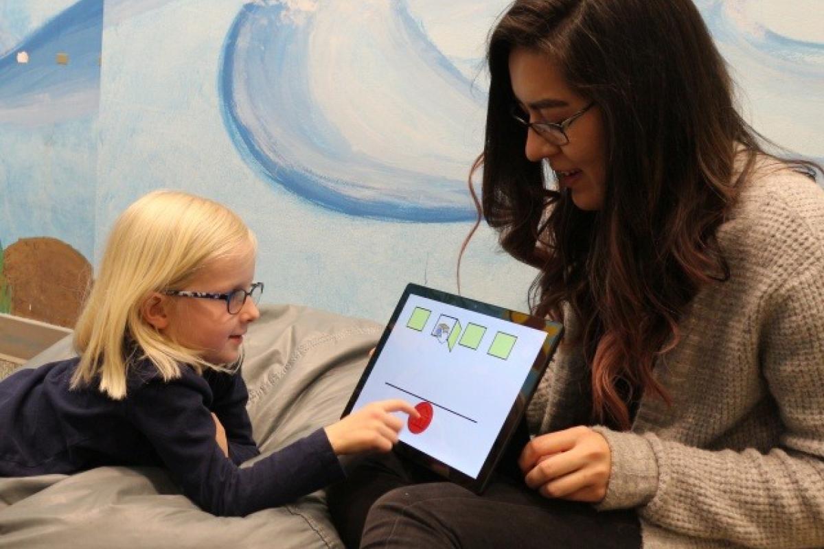 student helping child on ipad