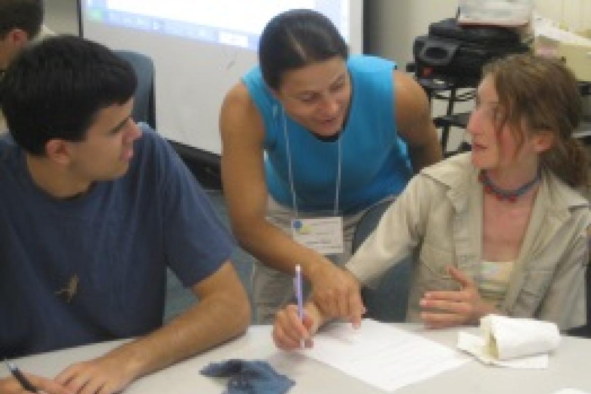 woman helping two students