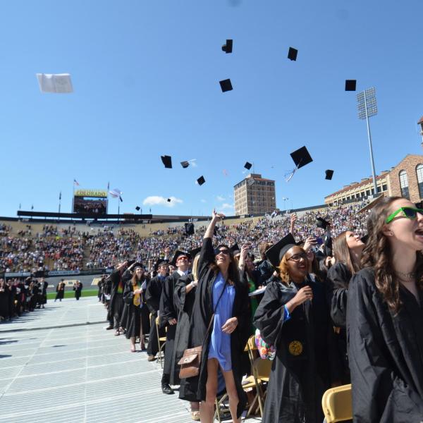 students throwing their caps on graduation day