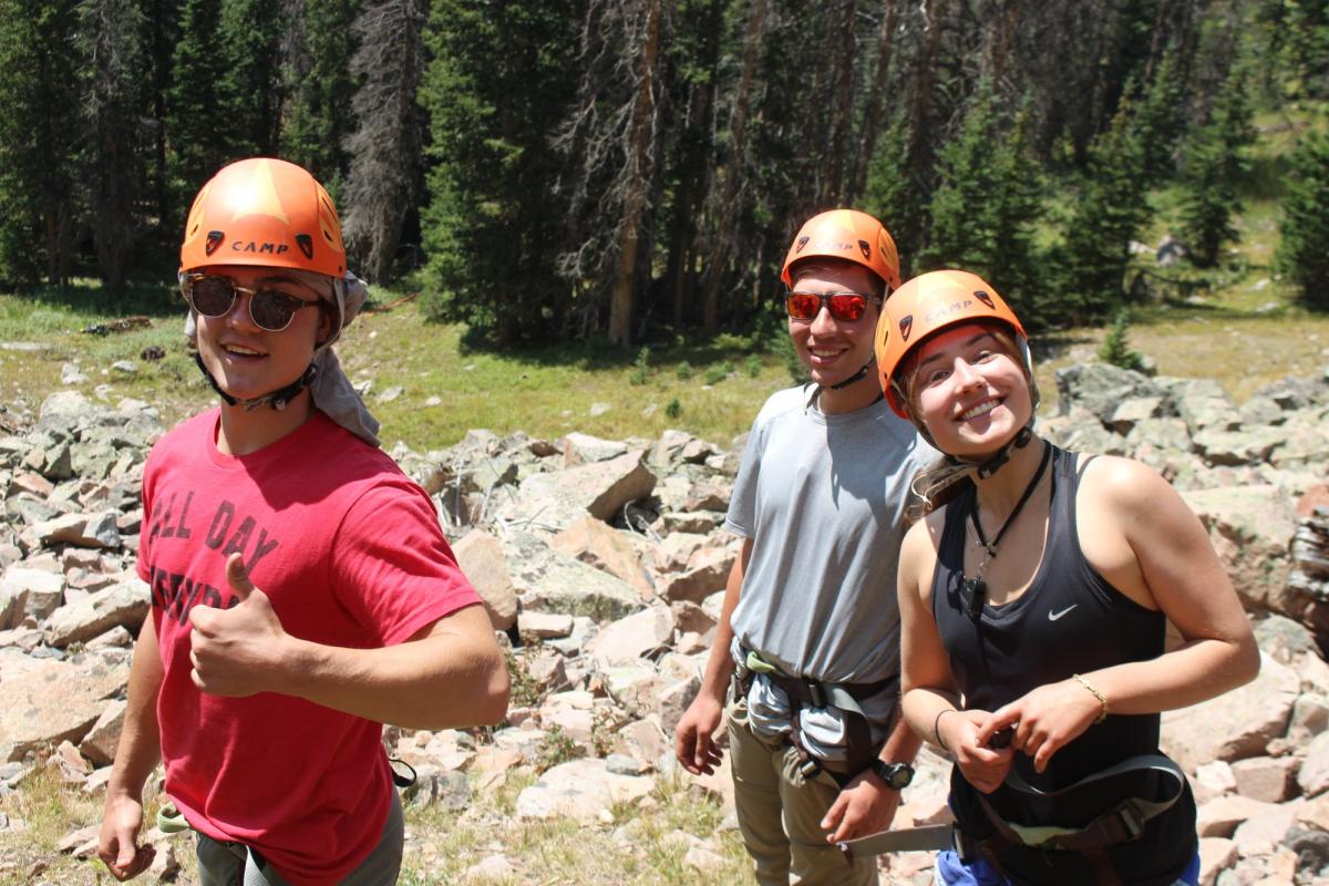 Three people wearing helmets