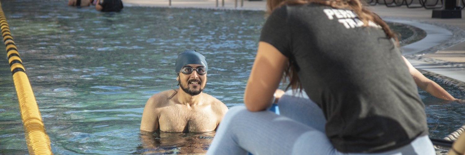 Student getting private swim lessons in outdoor pool