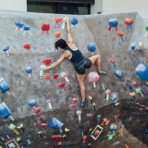 Female student bouldering in climbing gym